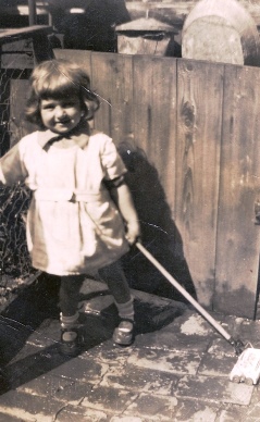 Young girl with brush in yard